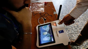 The finger of an Iraqi election official opens a device to start the legislative elections in Iraq, in Sadr City, Baghdad, October 10, 2021. (Reuters)