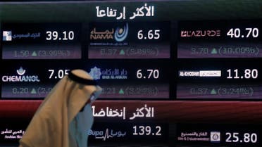 An investor walks past a screen displaying stock information at the Saudi Stock Exchange (Tadawul) in Riyadh, Saudi Arabia. (File photo: Reuters)
