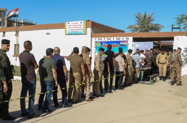 Members of Iraqi security forces line up outside a polling station waiting to cast their vote in a special process, two days ahead of Iraq's parliamentary elections, in Baghdad, Iraq October 8, 2021. (Reuters)