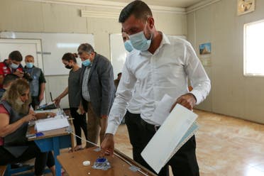 Darwesh Khodeda Hassan, a displaced Yazidi man, casts his vote at a polling station, two days ahead of Iraq's parliamentary elections in a special process, at the Sharya camp in Duhok, Iraq, October 8, 2021. (Reuters)