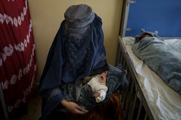 A woman holds one of her two babies undergoing treatment at the malnutrition ward of the Indira Gandhi Children's Hospital in Kabul, Afghanistan, Tuesday, Oct. 5, 2021. (AP)