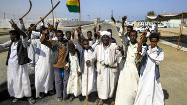 Members of the Beja group of eastern Sudan raise the flag of the Beja Congress political group as they demonstrate outside the Osman Digna port in Sudan's northeastern Red Sea coastal city of Suakin (Sawakin) on October 9, 2021, protesting against the Juba Peace Agreement, signed in October 2020 between the government and rebel groups. (AFP)