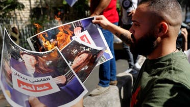 Supporters of Hezbollah and the Amal movement burn a portrait of Judge Tarek Bitar, the Beirut blast lead investigator, and US Ambassador to Lebanon Dorothy Shea near the Justice Palace, Oct. 14, 2021. (AFP)