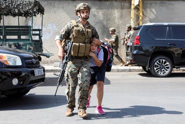 An army soldier helps a schoolgirl get to her parents, after a gunfire erupted in Beirut, Oct. 14, 2021. (Reuters)