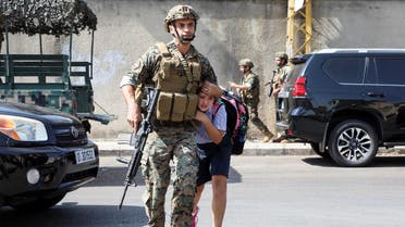 An army soldier helps a schoolgirl get to her parents, after a gunfire erupted in Beirut, Oct. 14, 2021. (Reuters)