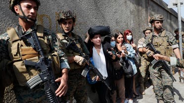 Lebanese teachers react to the sounds from nearby armed clashes as they flee their school under the protection of Lebanese soldiers after a clashes erupted along a former 1975-90 civil war front-line between Muslim Shia and Christian areas at Ain el-Remaneh neighborhood, in Beirut, Lebanon. (File photo: AP)