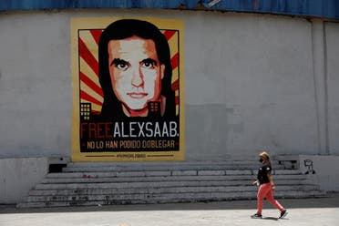 A woman walks by a mural in support of the liberation of businessman Alex Saab, who was detained in Cape Verde on charges of laundering money for the government of Venezuelan President Nicolas Maduro, in Caracas. (Reuters)