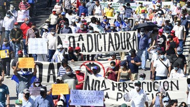 People take part in a demonstration against the circulation of Bitcoin and other economic measures, as well as a decree that removed judges from their functions, in San Salvador, on October 17, 2021.  (AFP)
