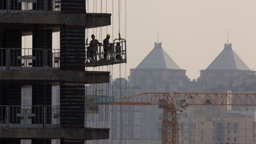 Men work at the construction site of a highrise building in Beijing, China, on October 18, 2021. (Reuters)