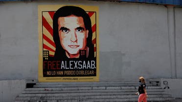 FILE PHOTO: A woman walks by a mural in support of the liberation of Colombian businessman and envoy Alex Saab, who is detained in Cape Verde on charges of laundering money for the government of Venezuelan President Nicolas Maduro, in Caracas, Venezuela September 9, 2021. REUTERS/Leonardo Fernandez Viloria/File Photo