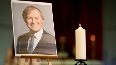 A candle and a portrait of British MP David Amess, who was stabbed to death during a meeting with constituents, are seen at the church of St Michael's and all Angels, in Leigh-on-Sea, Britain, October 17, 2021. REUTERS/Chris Radburn