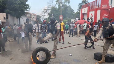 Police remove a burning tyre as Haitians mount a nationwide strike to protest a growing wave of kidnappings, days after the abduction of a group of missionaries, in Port-au-Prince, Haiti October 18, 2021. (Reuters)