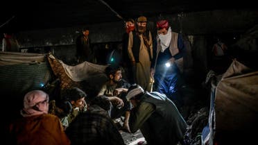 This picture taken on October 9, 2021 shows a man (top R) searching for his brother with his friends under a bridge where hundreds of addicted people gather in Kabul. (File photo: AFP)