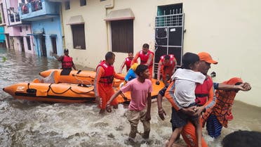 Members of National Disaster Response Force (NDRF) evacuate people to safer places from a flooded area in Udham Singh Nagar in the northern state of Uttarakhand, India, October 19, 2021. (Reuters)