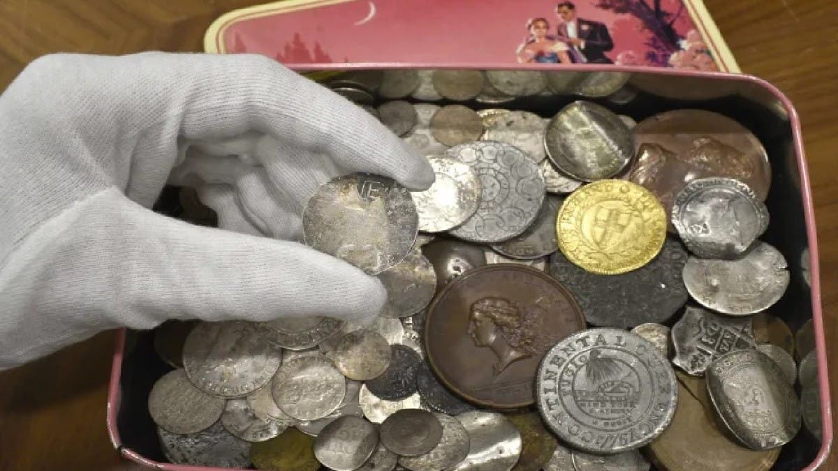 A pile of new and old Philippine peso coins with one thousand