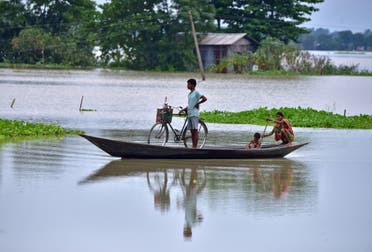 People move in a boat through a flooded field in Morigaon district in the northeastern state of Assam, India, September 1, 2021. REUTERS/Anuwar Hazarika