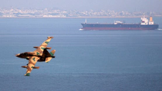 FILE PHOTO - An Iranian military fighter plane flies past an oil tanker during naval manoeuvres in the Gulf and Sea of Oman April 5, 2006. REUTERS/Fars News/File Photo