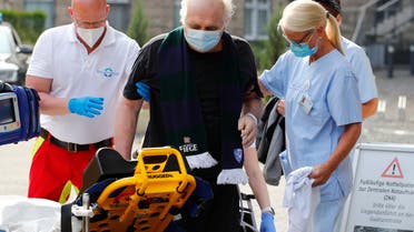 Claudio Facoetti, 65, from the northern Italian city of Bergamo, near Milan, walks on his own with the help of intensive care nurse Angela to a stretcher after leaving the university clinic Saint Josef of Bochum where he recovered within six weeks from the coronavirus disease (COVID-19) in Bochum, Germany, May 9, 2020. REUTERS/Wolfgang Rattay
