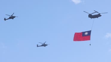 A helicopter carries a Taiwan flag during the national day celebration in Taipei, Taiwan, Oct. 10, 2021. (Reuters)