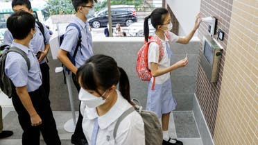 Secondary school students have their temperatures checked at the school entrance during the first day of the new term in Hong Kong, China September 1, 2021. Picture taken September 1, 2021. (Reuters)