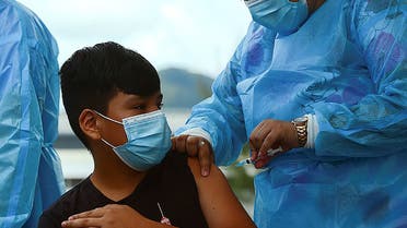 A boy receives the first dose of the Pfizer/BioNTech COVID-19 vaccine in Tegucigalpa, on September 25, 2021, during a vaccination program for teens aged 12 to 15. (AFP)