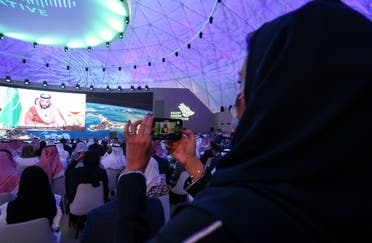 A woman records while Saudi Arabia's Crown Prince Mohammed bin Salman speaks during the Saudi Green Initiative Forum to discuss efforts by the world's top oil exporter to tackle climate change in Riyadh, Saudi Arabia, October 23, 2021. REUTERS/Ahmed Yosri