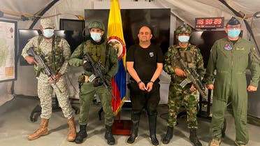 Dairo Antonio Usuga David, alias Otoniel, top leader of the Gulf clan, poses for a photo escorted by Colombian military soldiers after being captured, in Necocli, Colombia October 23, 2021. (Reuters)