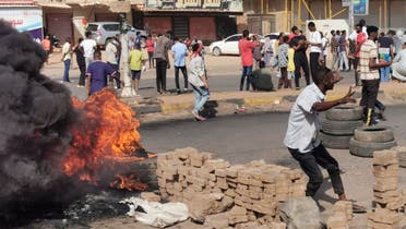 Sudanese protesters burn tyres to block a road in 60th Street in the capital Khartoum, to denounce overnight detentions by the army of members of Sudan's government, on October 25, 2021. (AFP)