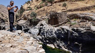 Nabil Musa, an Iraqi Kurdish environmental activist, takes pictures of Sirwan River on the outskirt of Halabja, Iraq June 13, 2021. (Reuters)