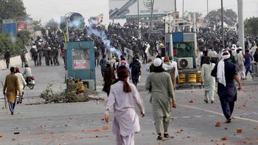 Supporters of Tehreek-e-Labiak Pakistan, a banned radical party, throw stones at police officers who fired teargas shells to disperse them during a protest march toward Islamabad, on the outskirts of Lahore, Pakistan, on Oct. 23, 2021. (AP)