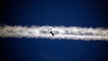 An aeroplane flies underneath the jet stream of another aircraft above the Italian city of Padova September 18, 2013. (Reuters)