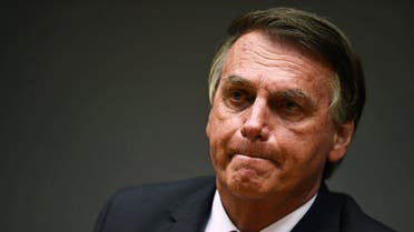 Brazilian President Jair Bolsonaro is seen during a press conference with his Economy Minister Paulo Guedes (out of frame) at the Ministry's headquarters in Brasilia, on October 22, 2021. (AFP)