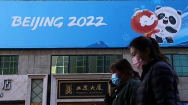 People walk past a banner with a sign of Beijing 2022 Winter Olympic Games, 100 days ahead of the opening of the event, in Beijing, China October 27, 2021. (Reuters)