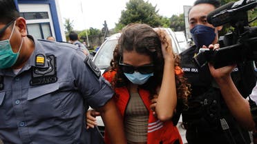 Heather Mack, an American woman jailed in 2015 with her boyfriend after being found guilty of playing a role for murdering her mother and stuffing the remains in a suitcase, is escorted by immigration officers after being released from Kerobokan Prison, at Immigration Detention House in Jimbaran, Badung, Bali, Indonesia, October 29, 2021. REUTERS/Johannes P. Christo