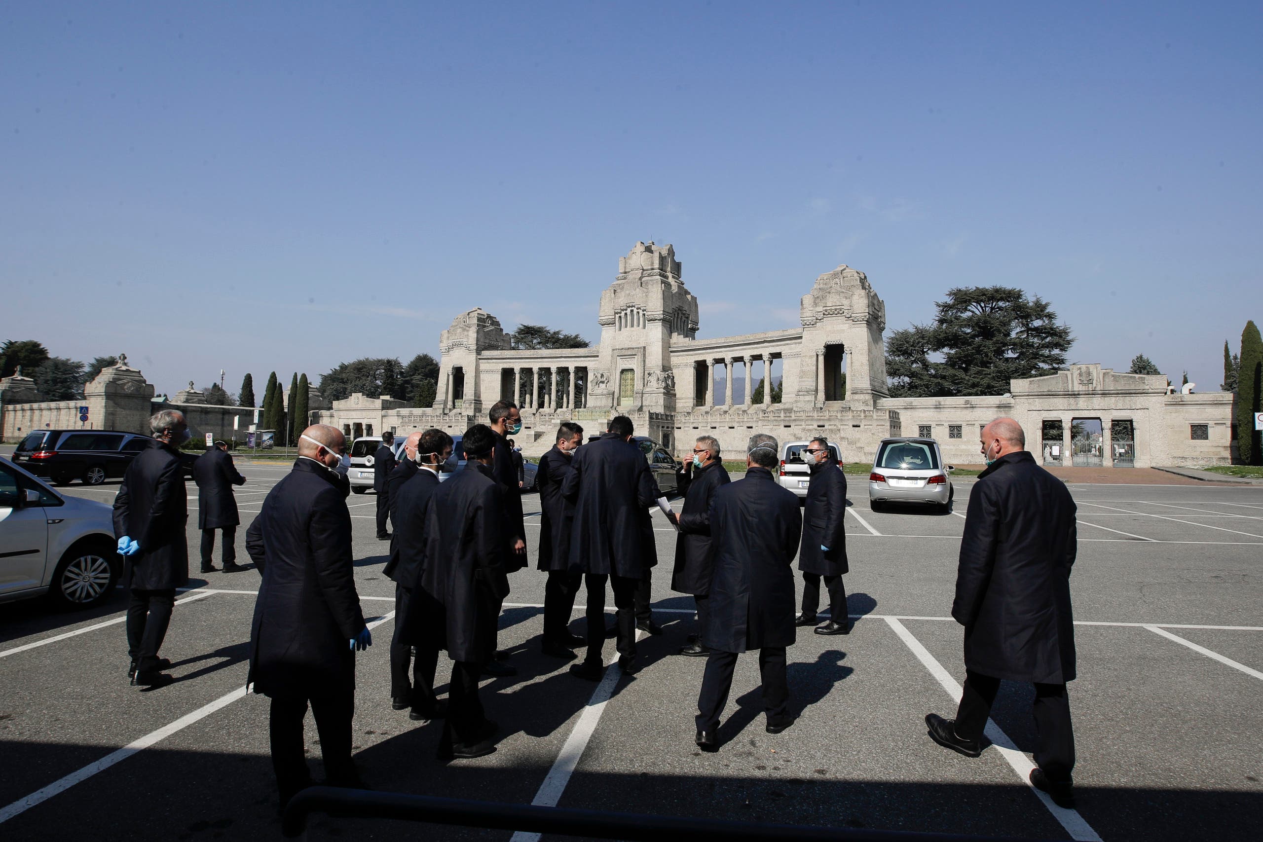 In this Tuesday, March 17, 2020 file photo, pallbearers stand outside the Monumentale cemetery, in Bergamo, the heart of the hardest-hit province in Italy's hardest-hit region of Lombardy, Italy. (AP)