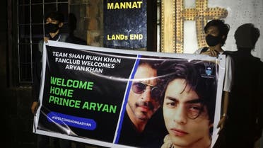 Fans of Bollywood superstar Shah Rukh Khan hold a poster outside his house, Mannat, after his eldest son Aryan Khan was granted bail by the Bombay High Court more than three weeks after he was arrested in a drugs case, in Mumbai, India, on October 28, 2021. (Reuters)