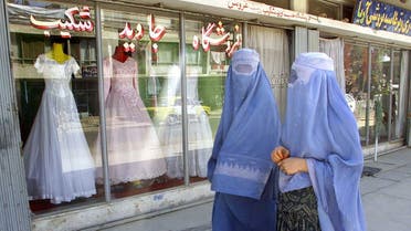 Afghan women walk past a shop specializing in wedding dresses in Kabul. (File photo: Reuters)