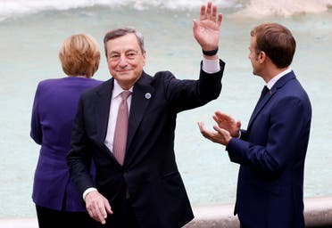 Italian Prime Minister Mario Draghi waves next to French President Emmanuel Macron and Germany's acting Chancellor Angela Merkel in front of the Trevi Fountain during the G20 summit in Rome, Italy, October 31, 2021. REUTERS/Guglielmo Mangiapane