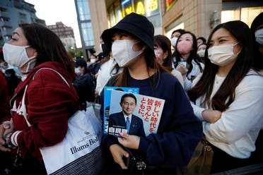 A voter holds a leaflet of Japan’s ruling Liberal Democratic Party with cover photos of the Prime Minister and the party president Fumio Kishida as she waits for the speech by Kishida, on the last day of campaigning for the October 31 lower house election, amid the coronavirus, in Tokyo, Japan, on October 30, 2021. Reuters)