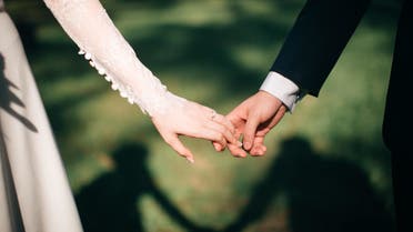 A bride and groom hold hands. (Unsplash, Jeremy Wong Weddings)