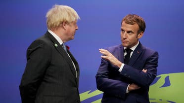 Britain's Prime Minister Boris Johnson (L) greets French President Emmanuel Macron as he arrives to attend the COP26 UN Climate Change Conference in Glasgow, Scotland on November 1, 2021. (AFP)