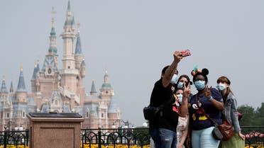  Visitors wearing protective face masks pose for a picture at Shanghai Disney Resort as the Shanghai Disneyland theme park reopens following a shutdown due to the coronavirus disease (COVID-19) outbreak, in Shanghai, China May 11, 2020. (File Photo: Reuters)