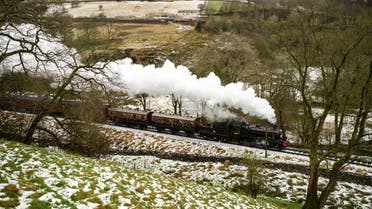 The 'Mince Pie Special' steam train service run along the line of the Keighley and Worth Valley Railway past snow covered fields near the village of Haworth, northern England on January 3, 2021. (AFP)