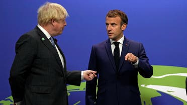 Britain's Prime Minister Boris Johnson greets French President Emmanuel Macron as he arrives to attend the COP26 UN Climate Change Conference in Glasgow, Scotland on November 1, 2021. (AFP)
