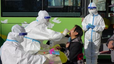 A medical worker in protective suit collects a swab during the fifth round of mass nucleic acid testing for residents of Aihui district following new cases of the coronavirus disease (COVID-19) in Heihe, Heilongjiang province, China October 31, 2021. Picture taken October 31, 2021. China Daily via REUTERS ATTENTION EDITORS - THIS IMAGE WAS PROVIDED BY A THIRD PARTY. CHINA OUT.
