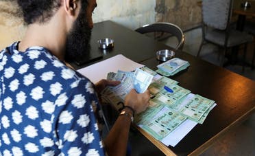 Moussa Yaakoub, a Lebanese pub owner, counts Lebanese pound banknotes in Beirut, Lebanon October 26, 2021. (Reuters/Issam Abdallah)