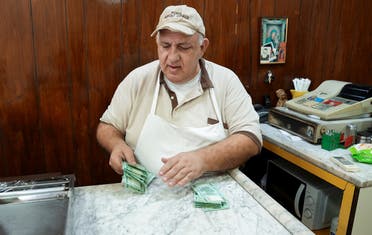 Antoine Haddad, known as Abou Chadi, a Lebanese restaurant owner, counts Lebanese pounds in Jal el-Dib, Lebanon October 26, 2021. (Reuters/Issam Abdallah)