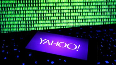 A photo illustration shows a Yahoo logo on a smartphone in front of a displayed cyber code and keyboard on December 15, 2016. (Reuters)