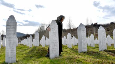 Vasva Smajlovic, a survivor of Srebrenica massacre in July 1995, stands next to her husband's tombstone, during visit at the Srebrenica-Potocari memorial cemetery on March 15, 2019. (AFP)