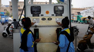 Workers enter the amount into a fuel pump machine before filling up the vehicles at a petrol station in Ahmedabad, India, October 11, 2021. Picture taken October 11, 2021. (Reuters)